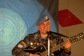 Олег рубежов ипослняет песню на фоне реликвии ДЮМ - флаге миротворческой операции ООН в Камбодже